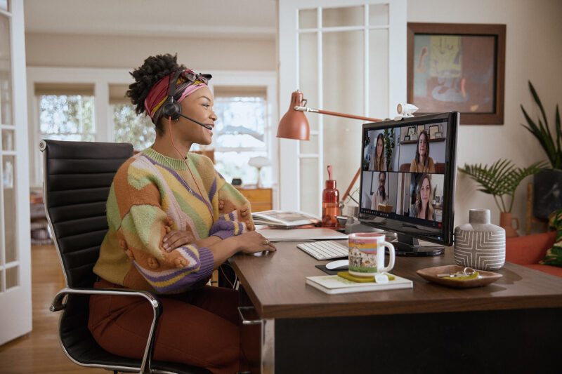 Image of woman wearing Plantronics headset smiling in video conference
