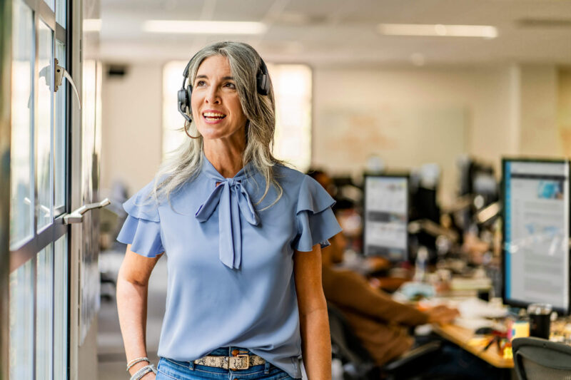 Image of woman wearing wireless Plantronics headset mid conversation while standing