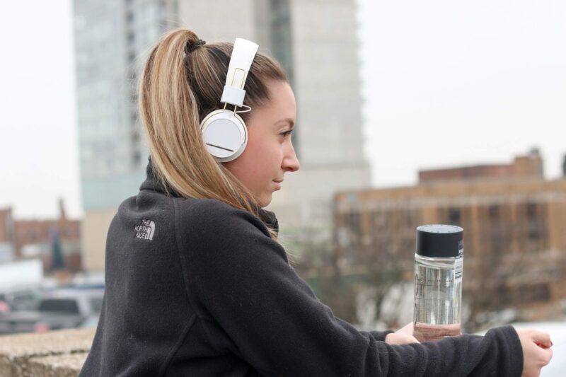 Image of woman outside wearing headphones and headsets