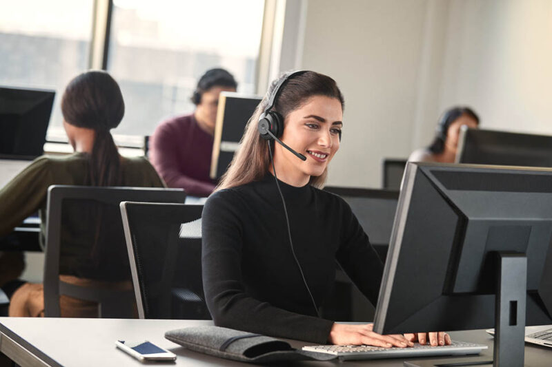 Image of woman wearing computer headset in office