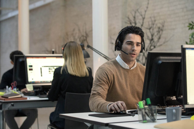 Man wearing dect epos headset in the office while working intently at computer