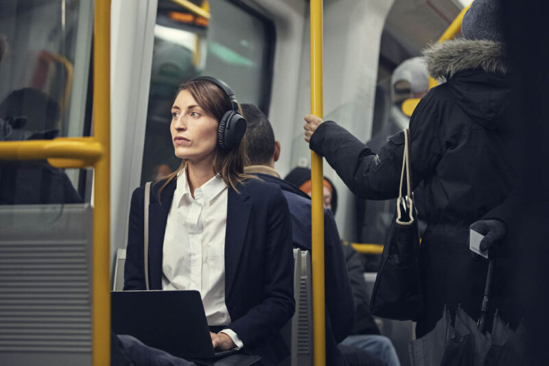Image of woman on train wearing noise cancelling headset