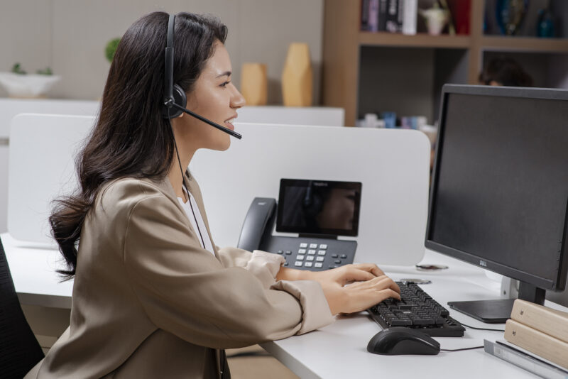 woman on call wearing headset with desk phones