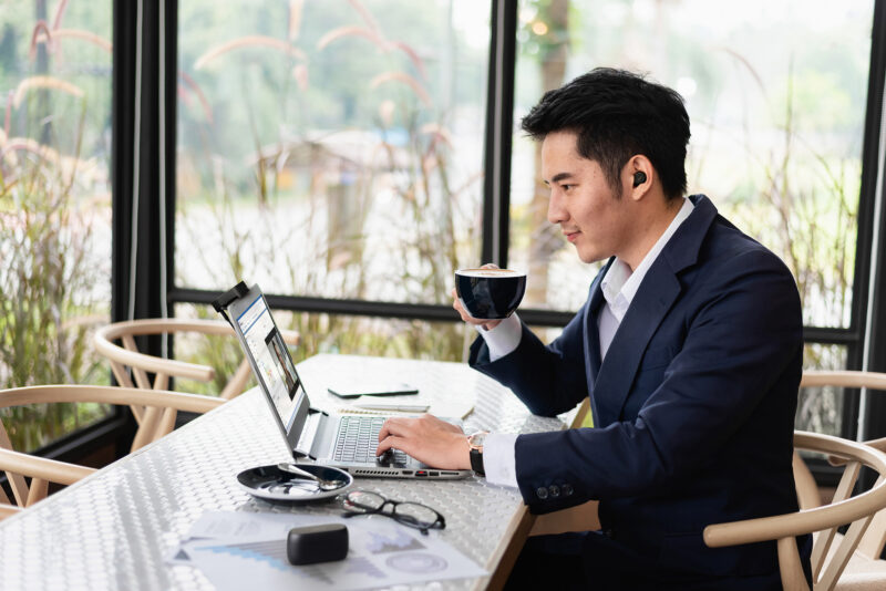 Man drinking coffee on work meeting call wearing UC and MS headsets