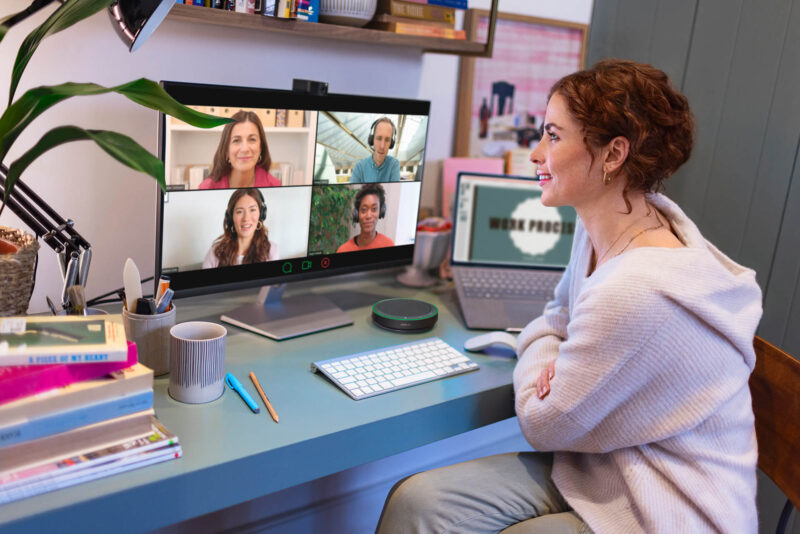Woman in video conferencing meeting sitting at desk